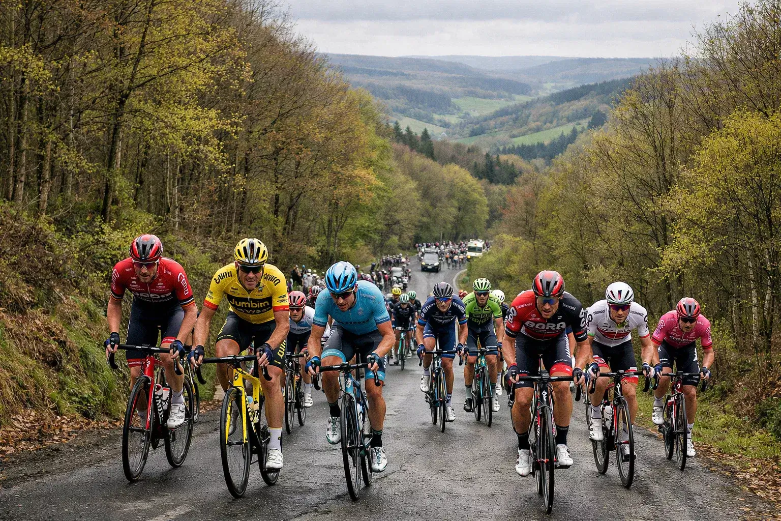 Gruppo di ciclisti professionisti che scala una delle cotes delle Ardenne belghe durante la Liegi-Bastogne-Liegi immersi nel paesaggio collinare